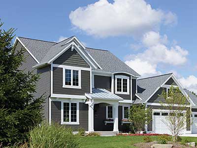 Front view of a mid-class home with dark gray Mastic siding